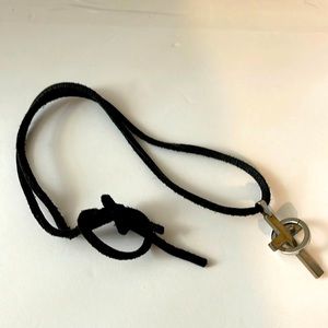 Leather string cross and metal loop entangled together